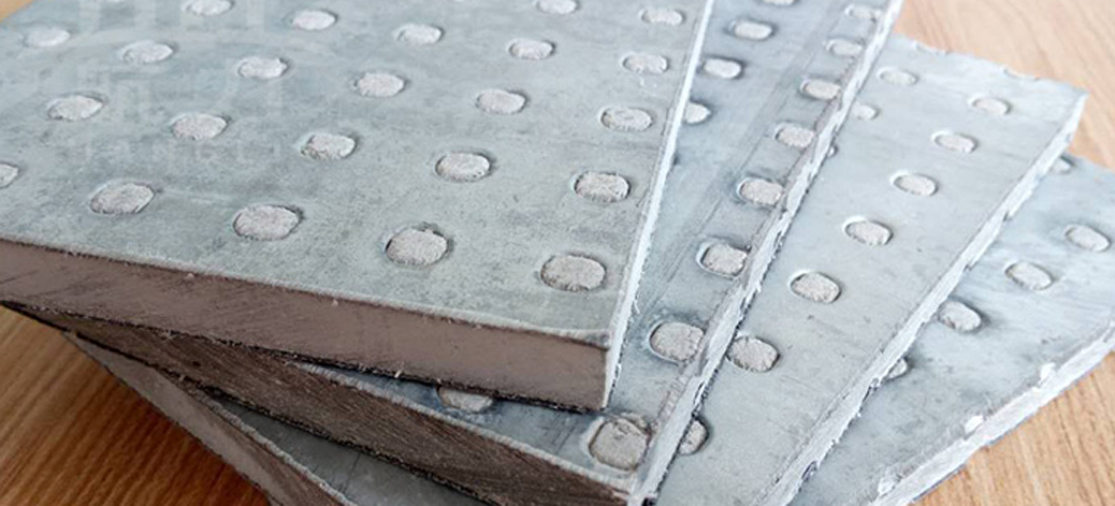 纖維水泥抗爆板又稱防爆板是為存在潛在爆炸危險區域、防震等特殊工作系統要求提供解決方案而研發生產的一種特殊板材，它是由增強纖維水泥板表面加壓鍍鋅鋼材料所構成，具有良好的抗爆及阻燃效果。由于板材內部特殊的構造可以有效減輕爆炸的沖擊，耐久性高，九德增強纖維水泥抗爆板依據專門爆破檢測機構的嚴格檢測，單板抗爆能力高達1.6MPa，抗爆墻抗爆能力高達2.0MPa，遠高于國家相關標準規定的墻體抗爆1.4Mpa。